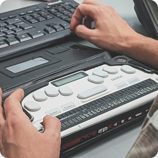 Persona non vedente che usa un display braille